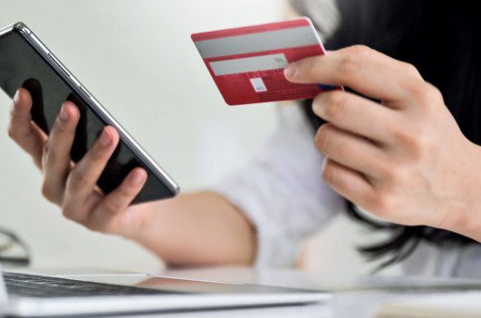 Traveler making an online booking with a bank card and smartphone