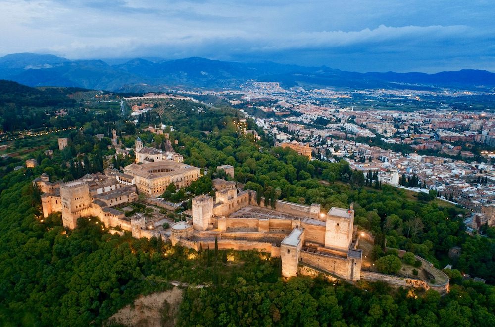Aerial view of the Alhambra palace complex in Granada, Spain, with the city in the background.