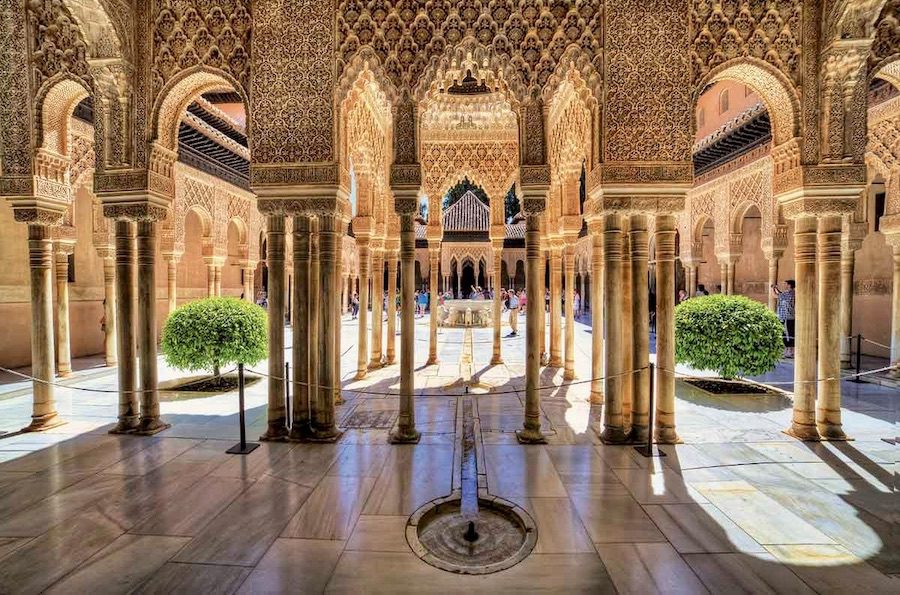Palace of the Lions at the Alhambra in Granada, showing its courtyard, shaded galleries, and water features designed for natural cooling.