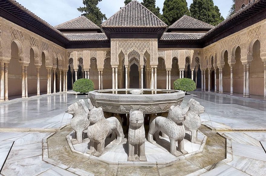 The Court of the Lions in the Nasrid Palaces of the Alhambra, Granada, featuring its famous fountain supported by twelve sculpted marble lions.