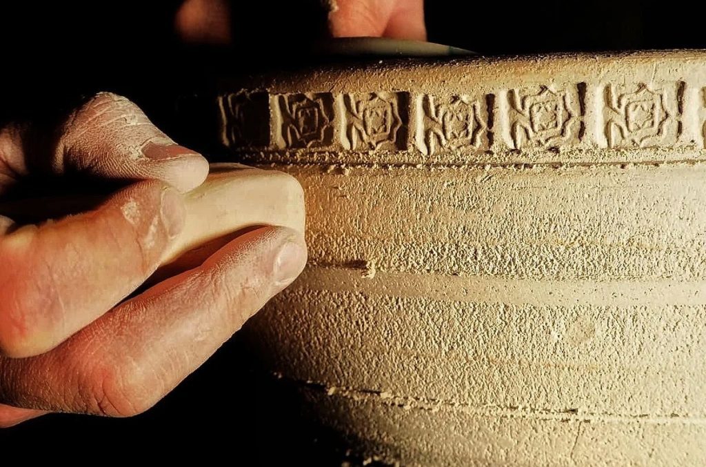 Hands of an artisan working on a ceramic piece inspired by the artistic heritage of Al-Andalus at Saedile, in Spain.